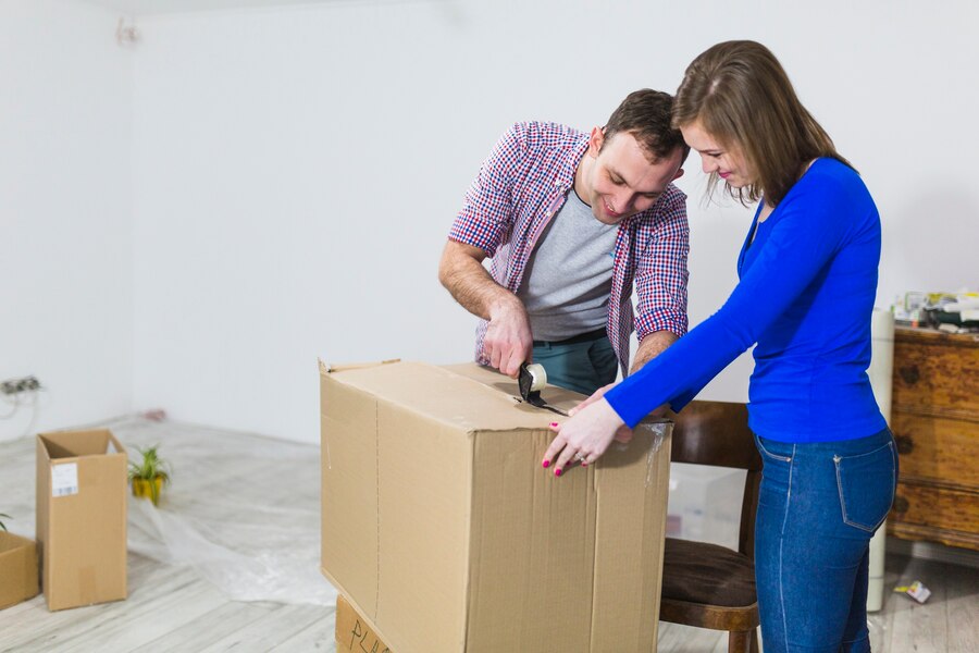 cheerful-couple-sealing-box_23-2147782396
