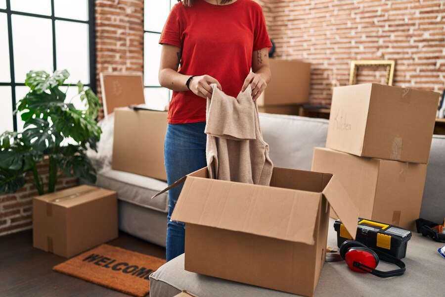 young-beautiful-hispanic-woman-unpacking-cardboard-box-new-home_839833-33657